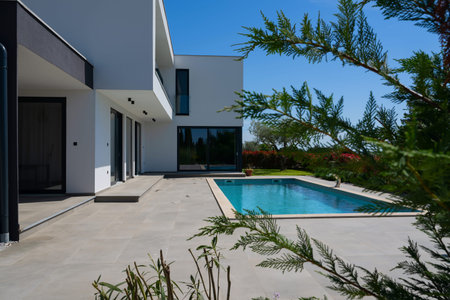 Modern luxury villa with swimming pool and clean minimalist architecture under a blue sky....