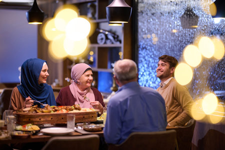 Ramadan iftar gathering with family sharing food and laughter at a cozy restaurant during evening