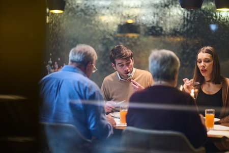 Gathering for iftar during Ramadan with family sharing moments at the table in a cozy settingの写真素材