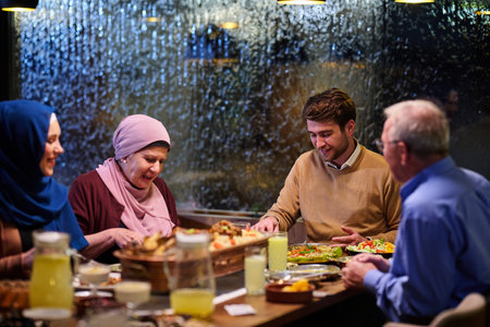 Muslim family enjoys iftar meal together in restaurant during Ramadan with traditional decorationsの写真素材