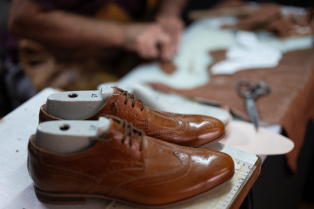 Brown leather dress shoes on lasts at a cobblers workshop during repair and craftsmanship