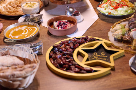 Muslim family sharing iftar meal in restaurant with Ramadan decorations and traditional foodの写真素材