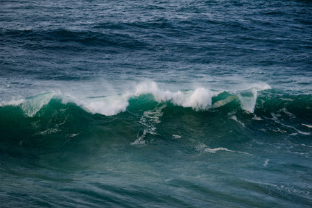 Powerful ocean waves crash and curl, capturing turquoise water, white foam, and raw sea energy
