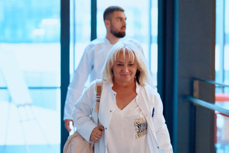Health professionals walking through modern hospital corridor, showcasing teamwork and care in healthcare environmentの写真素材