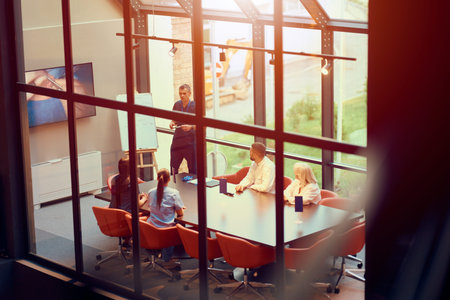 Team meeting in a modern conference room with a large window during the dayの写真素材