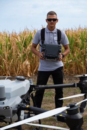 Drone pilot in a cornfield with remote controller and drone equipment for agricultural fieldwork