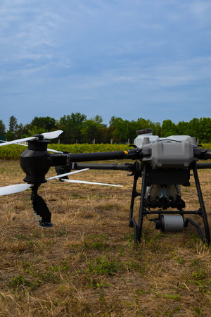 Agricultural drone ready for field operations with propellers and landing gear in an open field