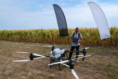 Drone operator tests agricultural drone in a cornfield with ground controlの写真素材