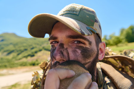 Soldier With Camouflage Face Paint Wearing Cap Applies Face Paint During Field Training Exercise