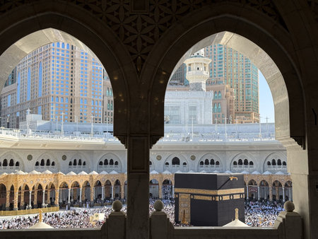 Pilgrims circling the Kaaba at Masjid al-Haram in Mecca framed by ornate mosque arches