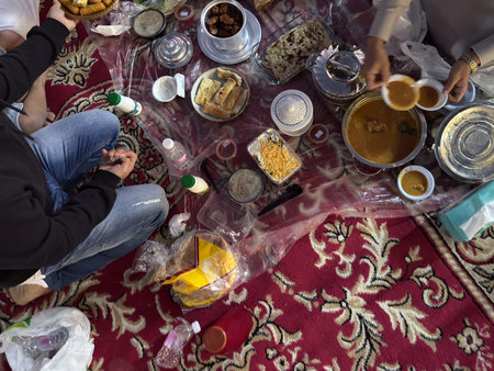 Realistic top view photograph of a traditional Arab family gathering around the table while...
