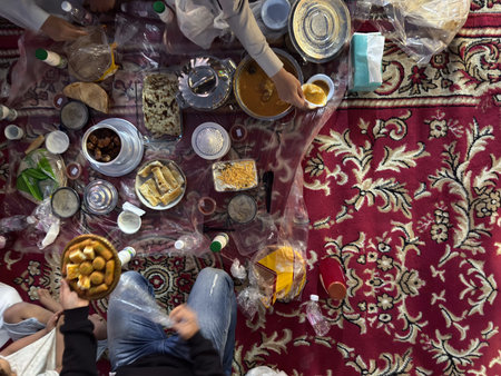Realistic top view photograph of a traditional Arab family gathering around the table while...