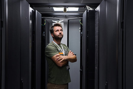IT technician inspecting servers in a data center server room with racks and network equipment