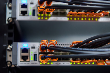 Close-up of network server rack with fiber optic cables and illuminated ports in data center