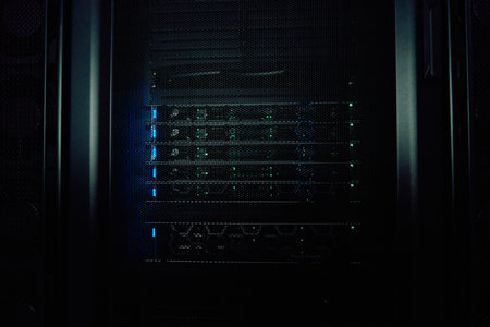 Dark server rack with glowing network equipment and status lights in a data center cabinet