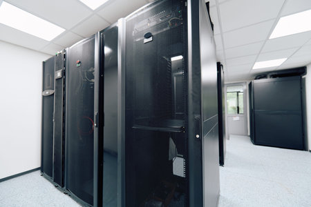 Modern data center server room with black server racks and network equipment in bright interior