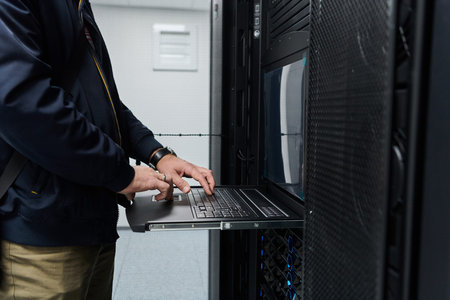 Data center technician working on a rack server using a slide-out laptop console