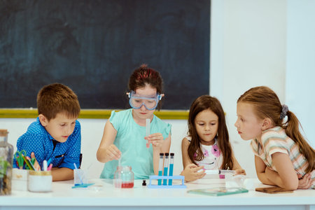 Children conducting a hands-on science experiment in a classroom as classmates observe and learn togetherの写真素材