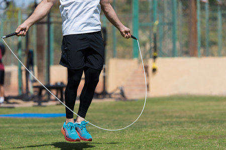 Man doing jump rope workout at outdoor gym for CrossFit cardio and fitness training