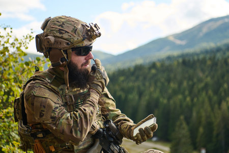 Bearded Tactical Soldier Using Radio and Notepad During Mountain Reconnaissance