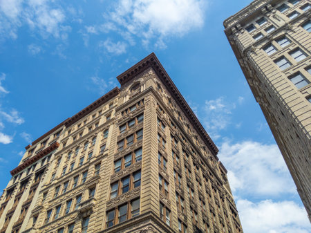 Looking up at old buildings in SoHo, Manhattan, New York City with blue skyの写真素材