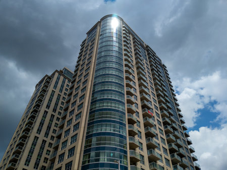 Looking up at reflective apartment building complex in Ottawa, Canada with cloudy skyの写真素材