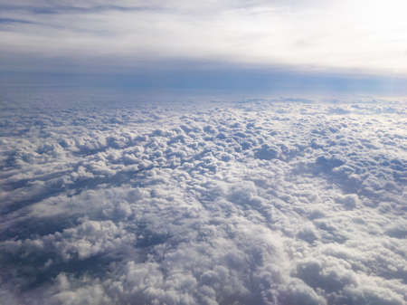 Aerial view between layers of small puffy altocumulus clouds and smooth altostratus cloudsの写真素材