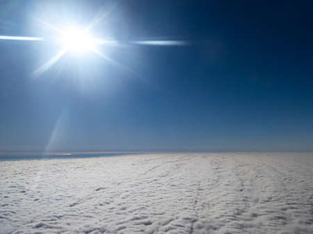 Aerial view above layer of altocumulus clouds with sun shiningの写真素材