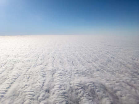 Aerial view above layer of altocumulus clouds with unique texture at middayの写真素材