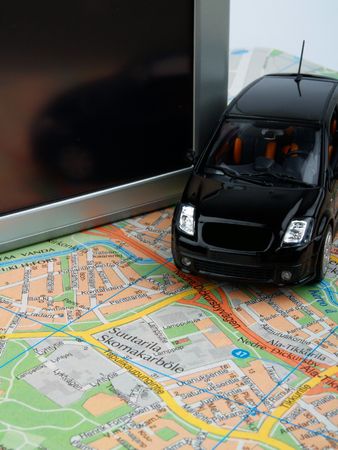 Toy car on a road map in front of a GPS unitの写真素材