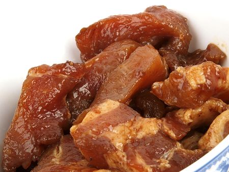 Marinated meat in a bowl close up on white background の写真素材