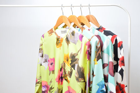 Clothes of different pattern on wooden hangers on isolated white background.の写真素材