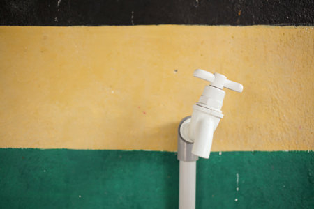 Water faucet with green and yellow wall background, stock photoの写真素材