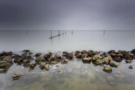 Lake Fishnets In Long Exposure With Moody Skyの写真素材