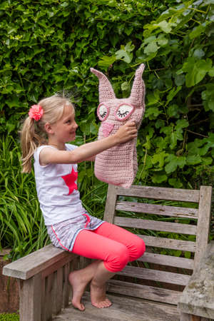 Young Girl Holding Homemade Crochet Toyの写真素材