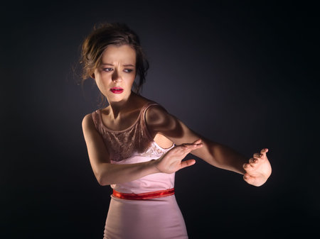 Young woman shying away from the lightの写真素材