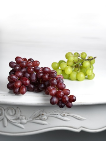 Red and white bunches of grapes on white table.の写真素材