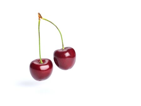 Ripe cherry berries floating on white backgroundの写真素材