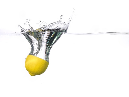 Lemon half falling into water, with a splash, white background の写真素材