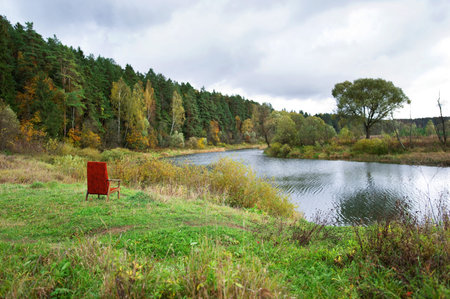 Red armchair by riverの写真素材