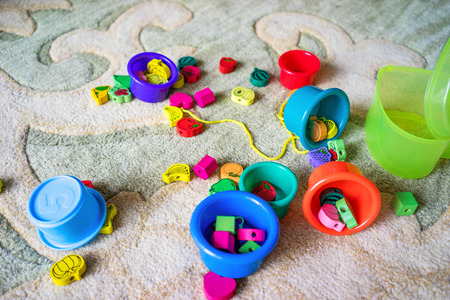 On the bright carpet lie a variety of children's toys.の写真素材