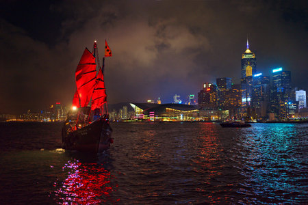 Hong Kong - November 19, 2015: Traditional boat with red sail and harbor at nightのeditorial素材