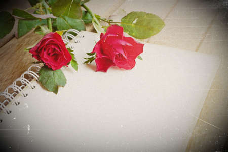 red roses flower and open notebook for text on wooden background, soft vintage toneの写真素材