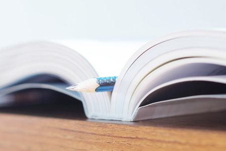 close-up of an open book with a pencil in the middleの写真素材