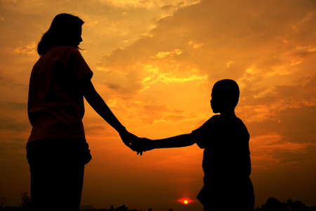 mother and son holding hand in sunset, mother day backgroundの写真素材
