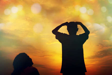 Mother and sun silhouettes at sunset with blur nature bokeh backgroundの写真素材