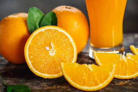 orange sliced and orange juice glasses with green leaf on wooden tableの写真素材
