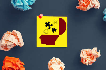 crumpled  paper with a jigsaw piece on man head shape or brain, mind and idea conceptの写真素材