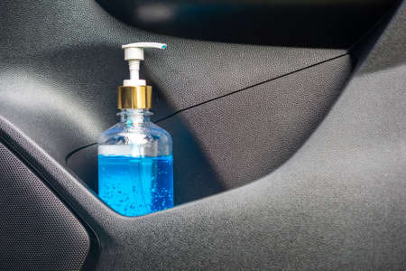 new normal lifestyle concept with closeup bottle of hand sanitizer alcohol gel in car for Corona or covid-19 virus preventionの写真素材