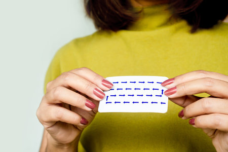 closeup female hand holding birth control pill